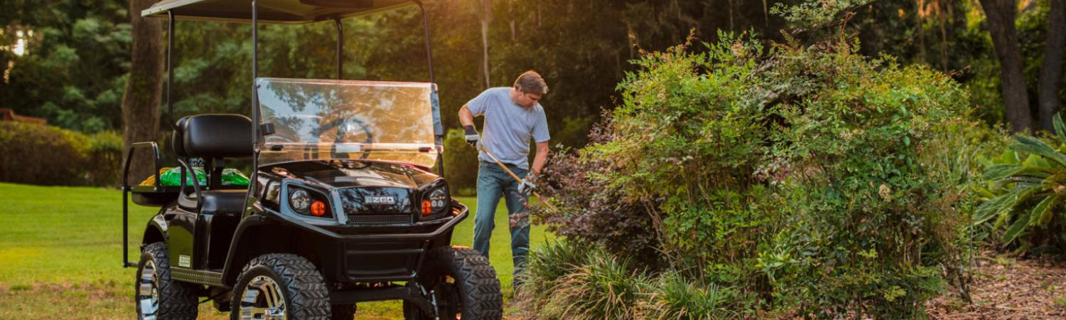Man working next to an 2020 E-Z-Go golf cart